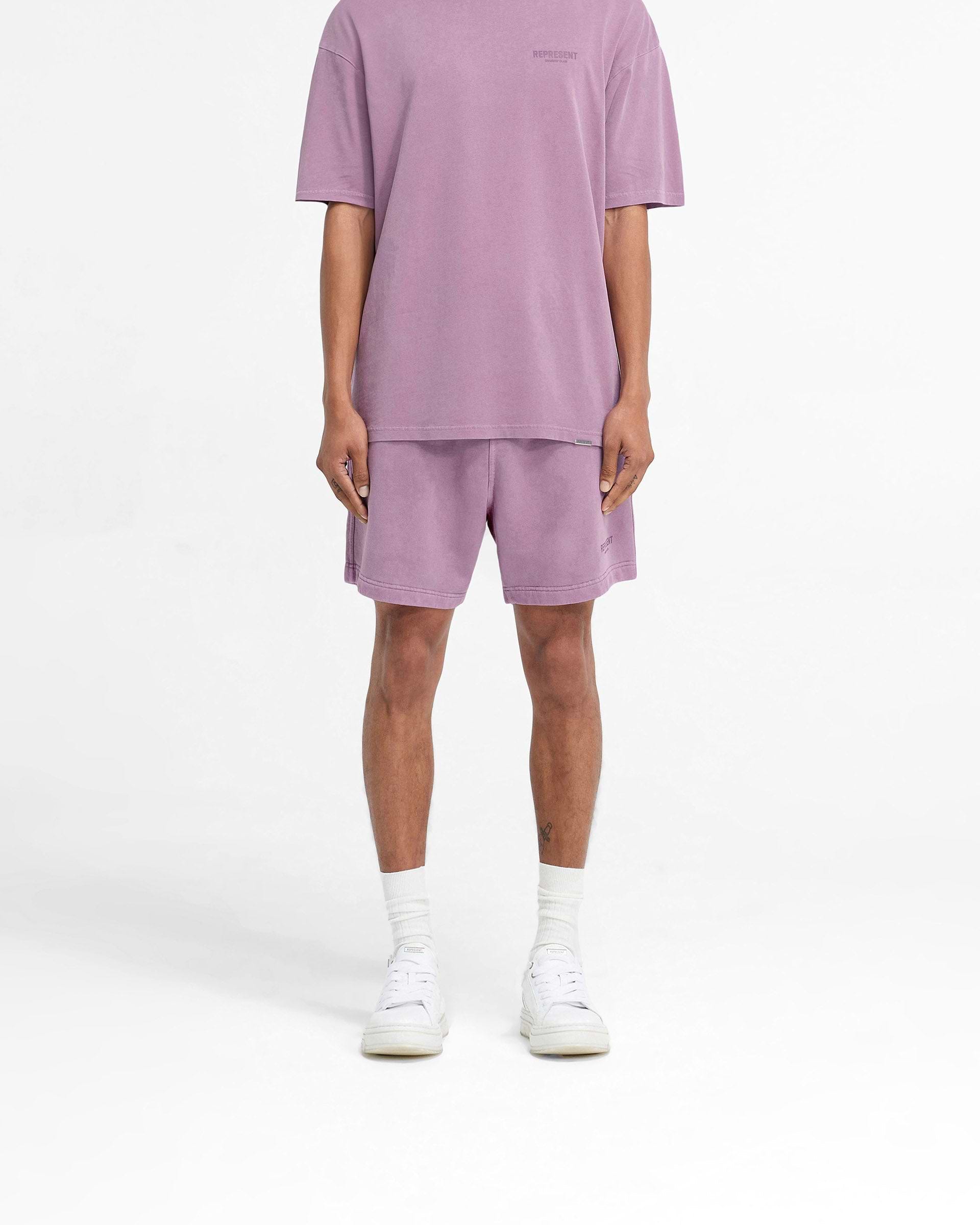 Man wearing purple shorts on a plain white background | Represent Owners Club Shorts in Mid Purple | Relaxed fit shorts with elasticated waistband | Owners Club Shorts | Represent Clo
