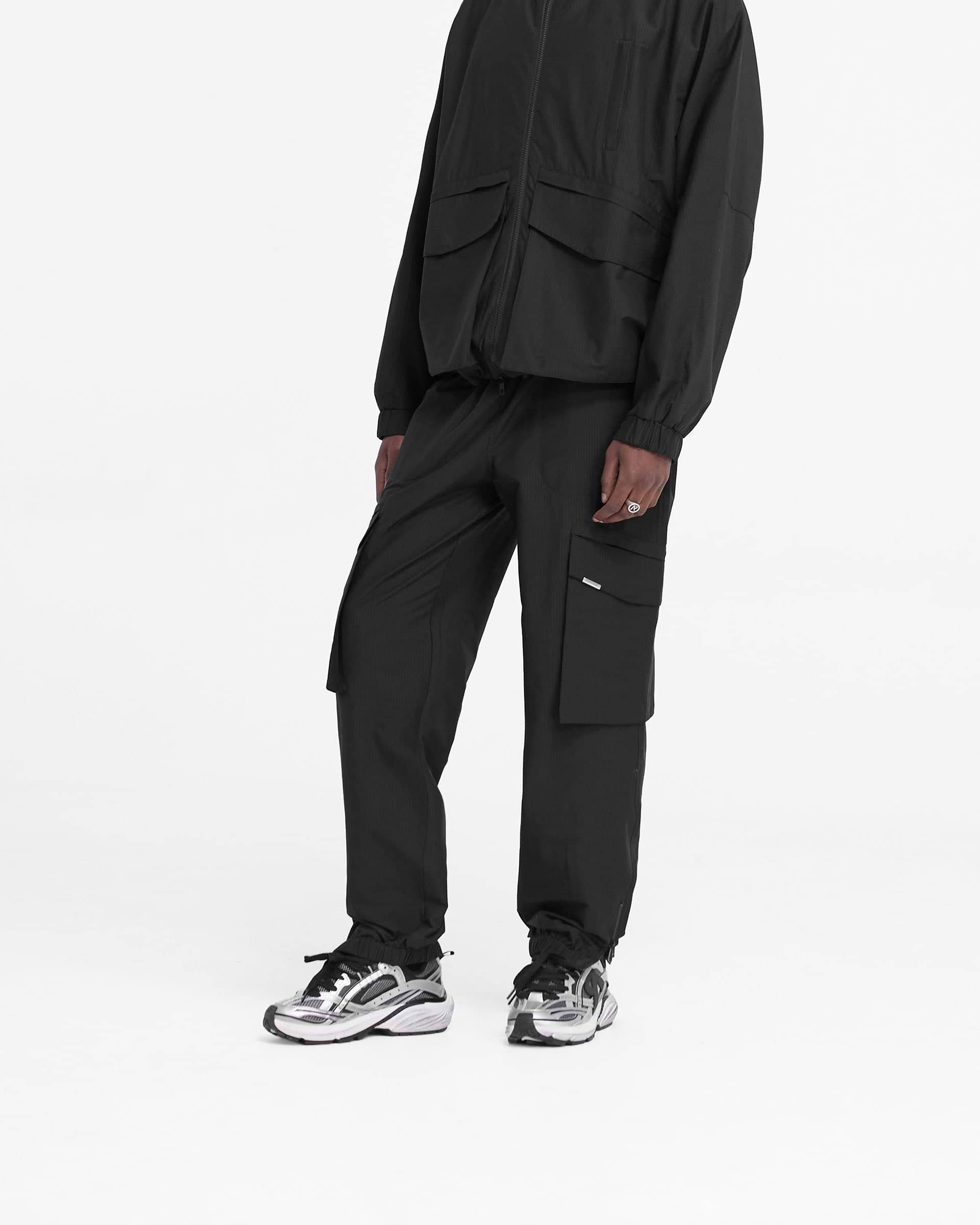 Back product image of mens black pants on a plain white background | Tech Cargo Pant in Jet Black | Pants with elasticated waistband and cargo pockets | FW24 Pants | Represent Clo