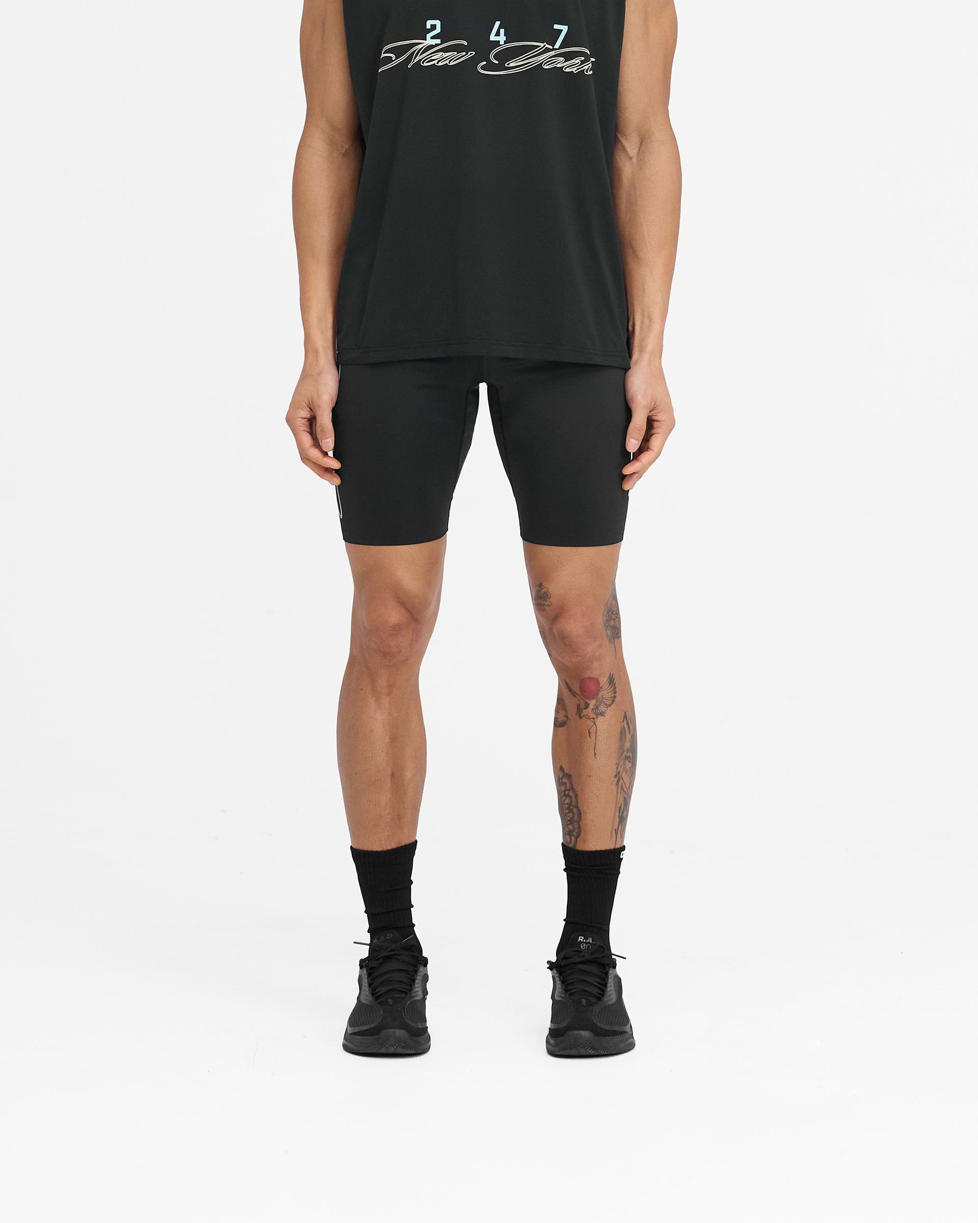 Man wearing black running half tights on a plain white background | 247 New York Half Tight in Black | Running shorts with 4-way stretch fabric | 247 Shorts | Represent Clo