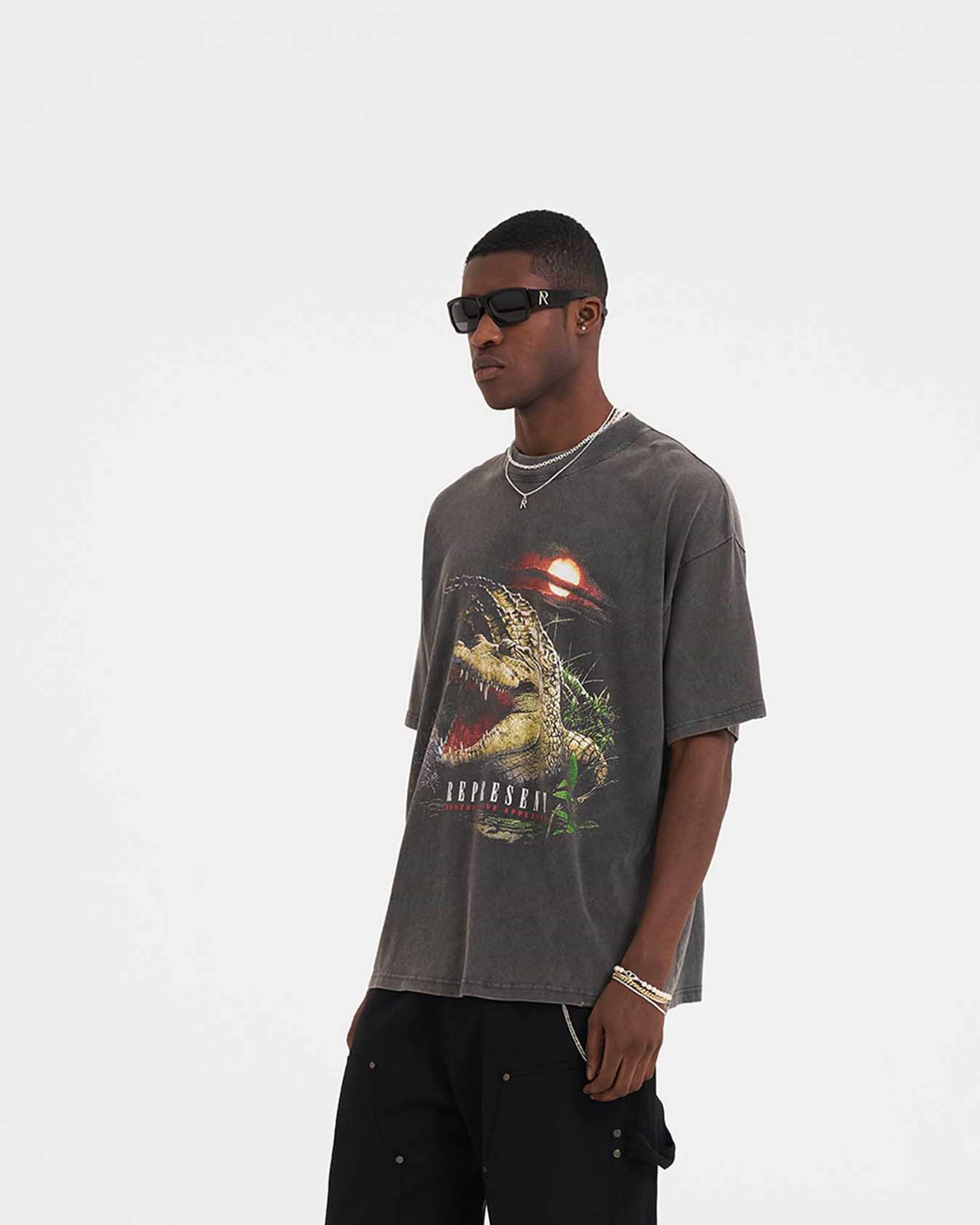 Man wearing a vintage grey graphic t-shirt on a plain white background | Destructive Appetite T-Shirt in Vintage Grey | Oversized fit t-shirt with ribbed crewneck and screen-printed graphic | SS23 T-Shirts | Represent Clo