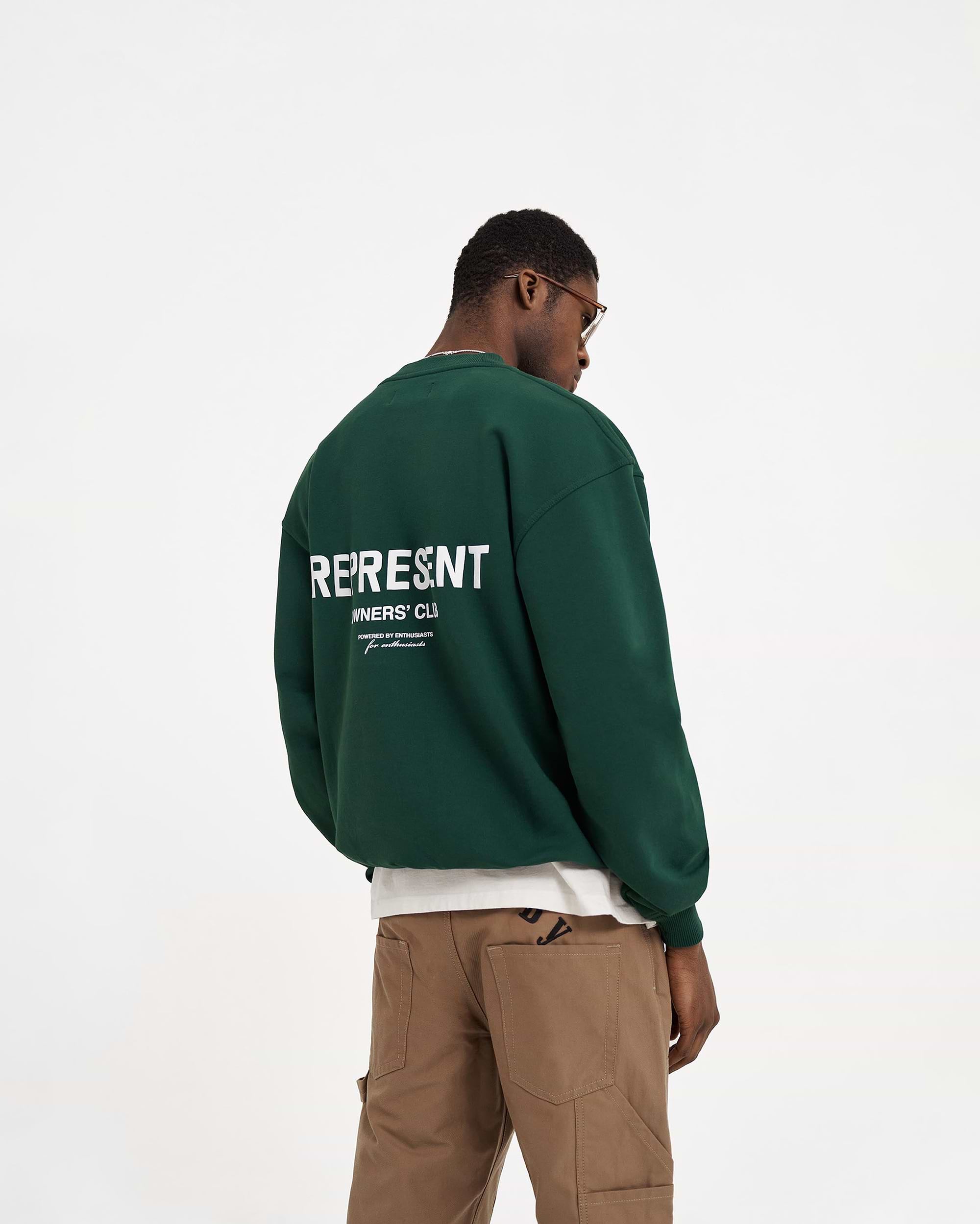Man wearing a green sweater on a plain white background | Represent Owners Club Sweater in Racing Green | Heavy weight oversized fit crewneck sweater | Owners Club Sweaters | Represent Clo